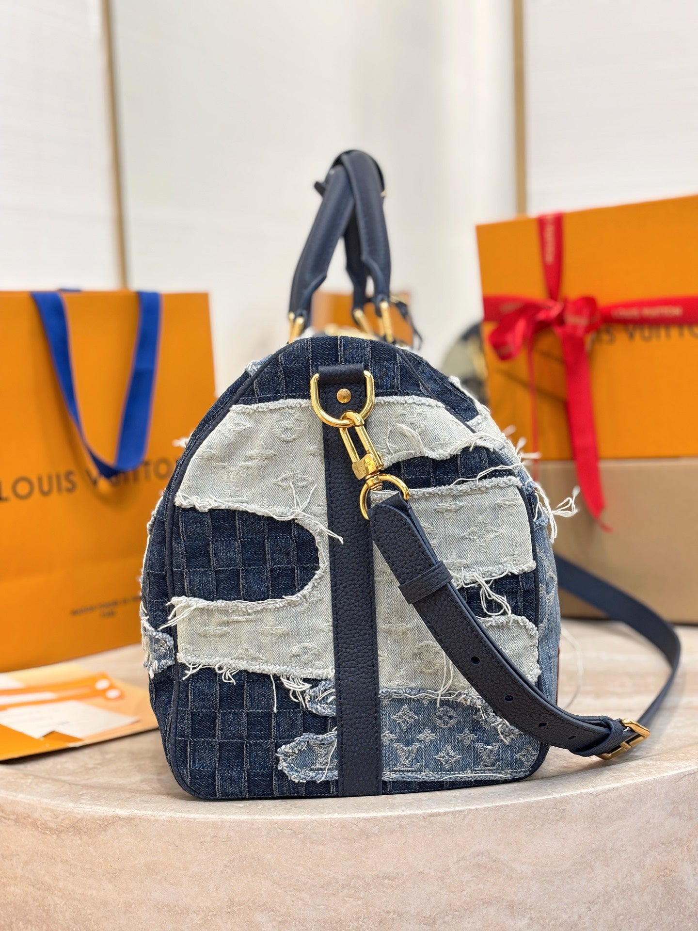 Louis Vuitton patchwork denim crossbody handbag with front strap and gold-tone buckle