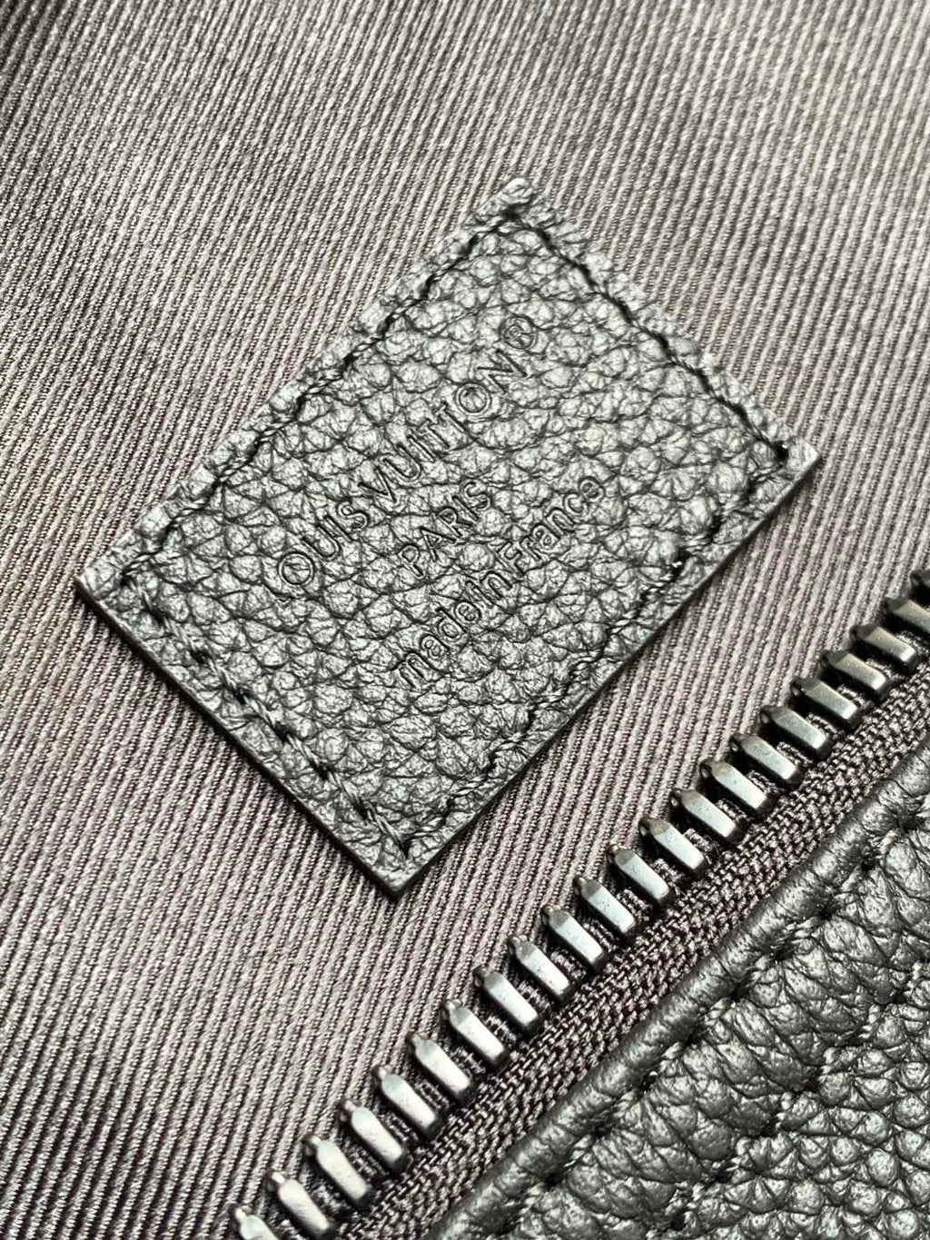 Stitched leather interior pocket with zipper teeth and textured grain