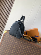 Dark blue leather men's duffel-style bag with curved top handle and adjustable strap