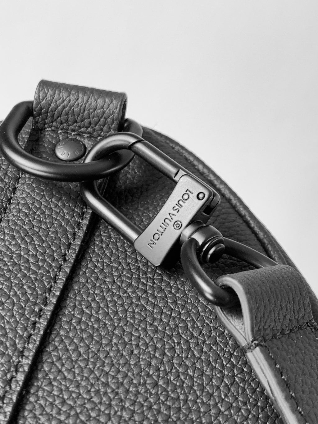 Dark leather bag with key ring, padlock charm, and chain hardware