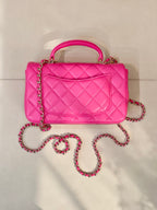 Chanel pink quilted handbag with top handle and long chain crossbody strap