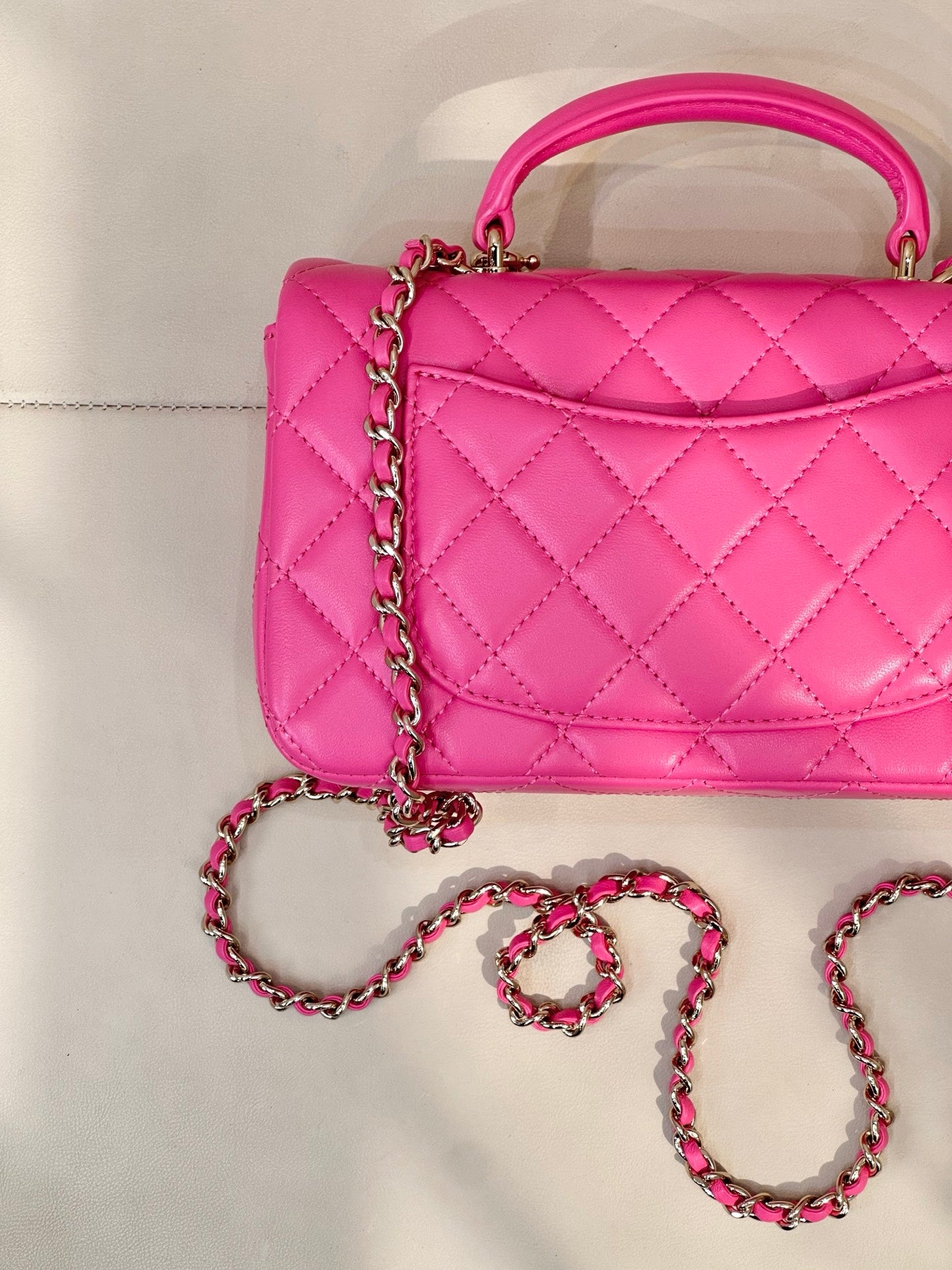 Chanel pink quilted bag close-up with chain strap and top handle