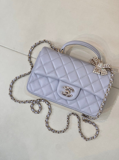 Quilted Chanel shoulder bag in light blue with diamond bow clasp and chain strap.