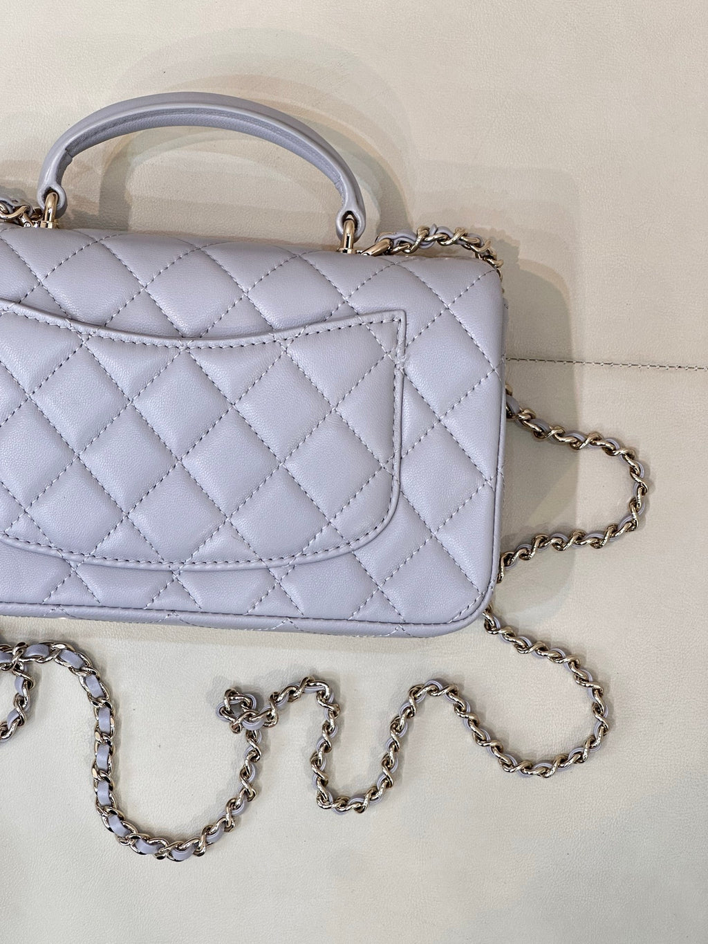 Light blue Chanel quilted flap bag with panel detail and chain strap.