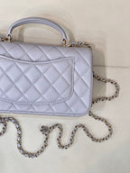 Light blue Chanel quilted flap bag with panel detail and chain strap.