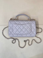 Light blue Chanel quilted top-handle shoulder bag with chain strap and clasp.