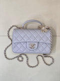 Quilted Chanel shoulder bag in light blue with flap, gold-tone logo, and chain strap.