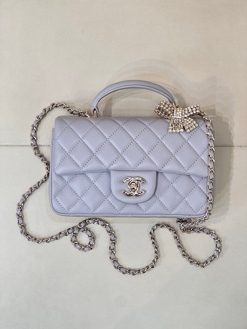Quilted Chanel shoulder bag in light blue with flap, gold-tone logo, and chain strap.
