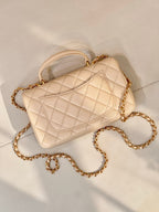 Chanel quilted leather shoulder bag with chain strap and logo flap in light beige, angled view