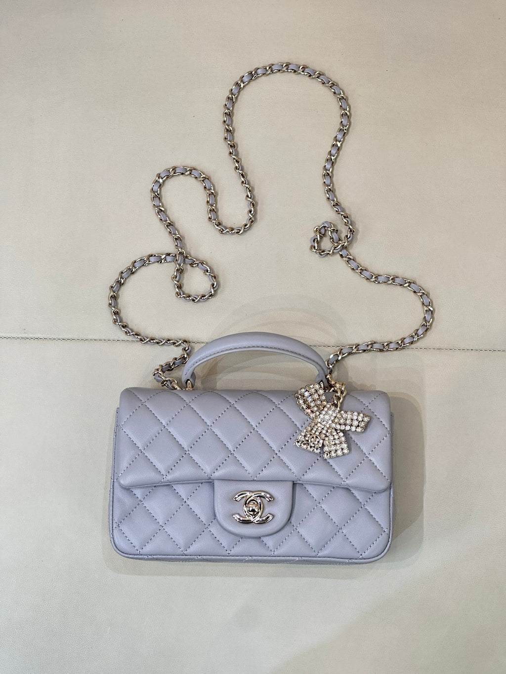 Light blue Chanel quilted crossbody bag with gold-tone CC logo and chain strap.