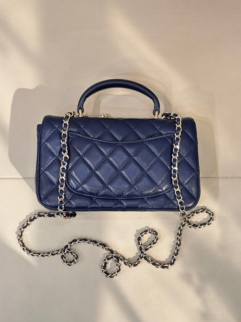 Quilted blue flap handbag with chain strap, top handle, diamond bow detail