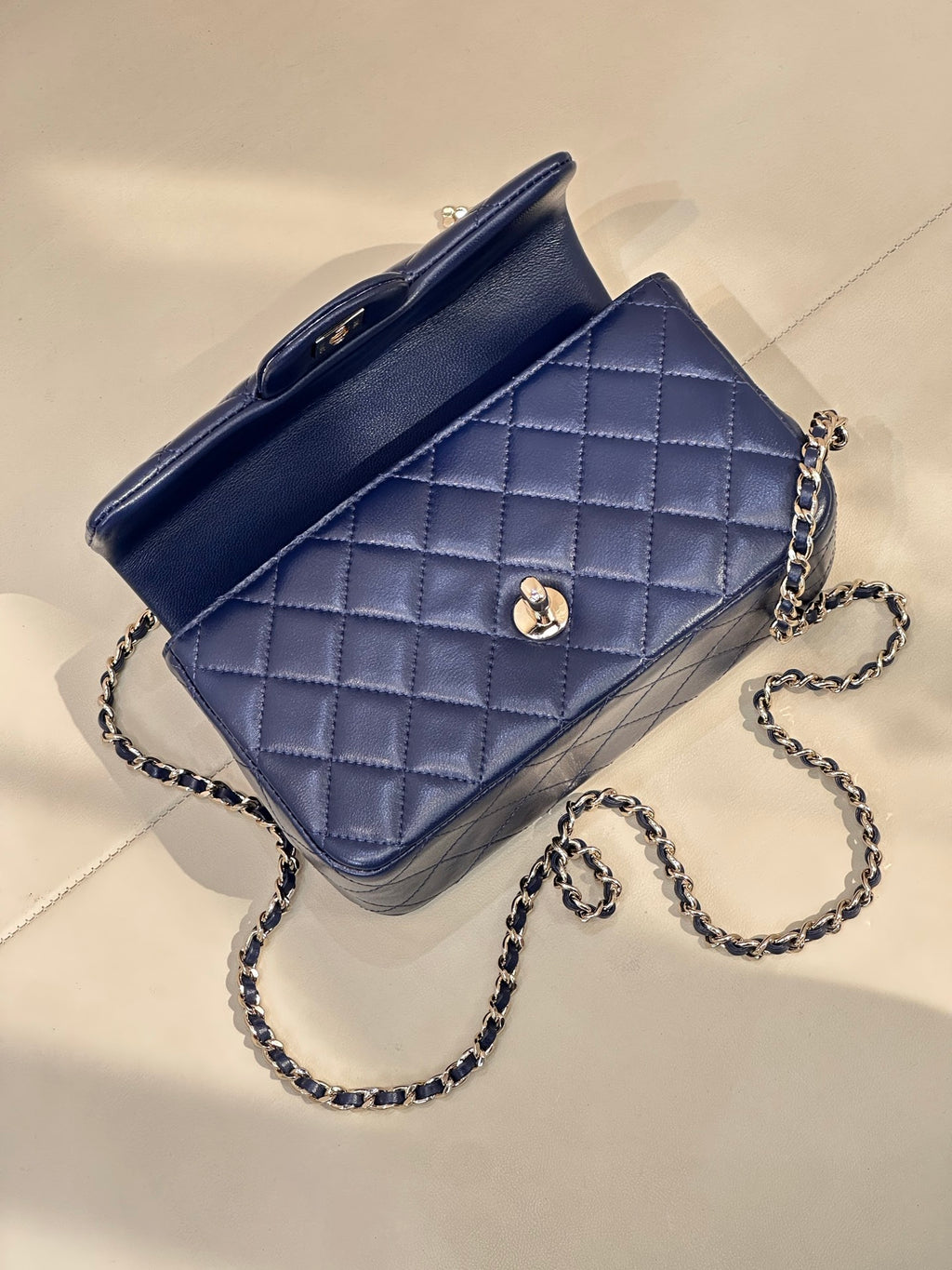 Quilted blue shoulder bag with chain strap, flap closure, small front medallion