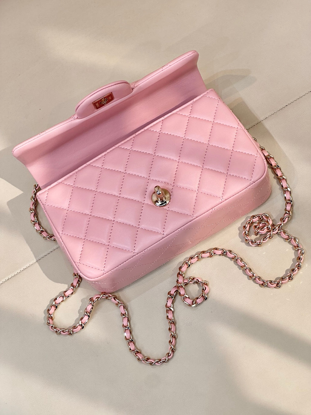 Chanel light pink quilted flap bag with short top handle, chain strap, and CC logo