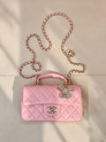 Chanel quilted pink flap bag with rhinestone bow charm, chain strap, and CC logo