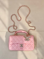 Chanel quilted pink flap bag with rhinestone bow charm, chain strap, and CC logo