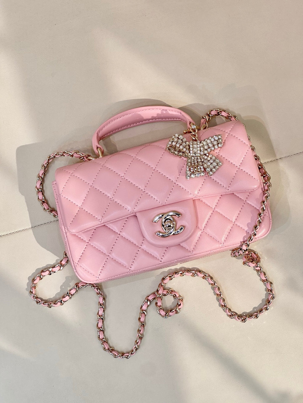 Chanel quilted pink crossbody bag with rhinestone bow detail and CC logo