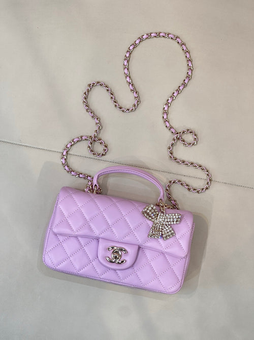Quilted light purple flap handbag with rhinestone bow charm and chain crossbody strap