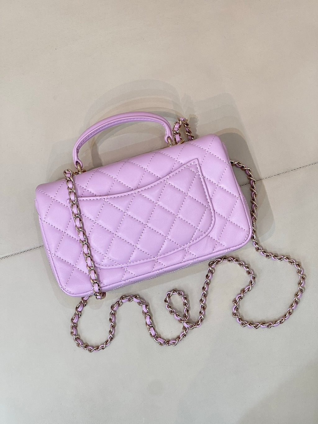 Quilted light purple mini handbag angled view with chain strap and front flap