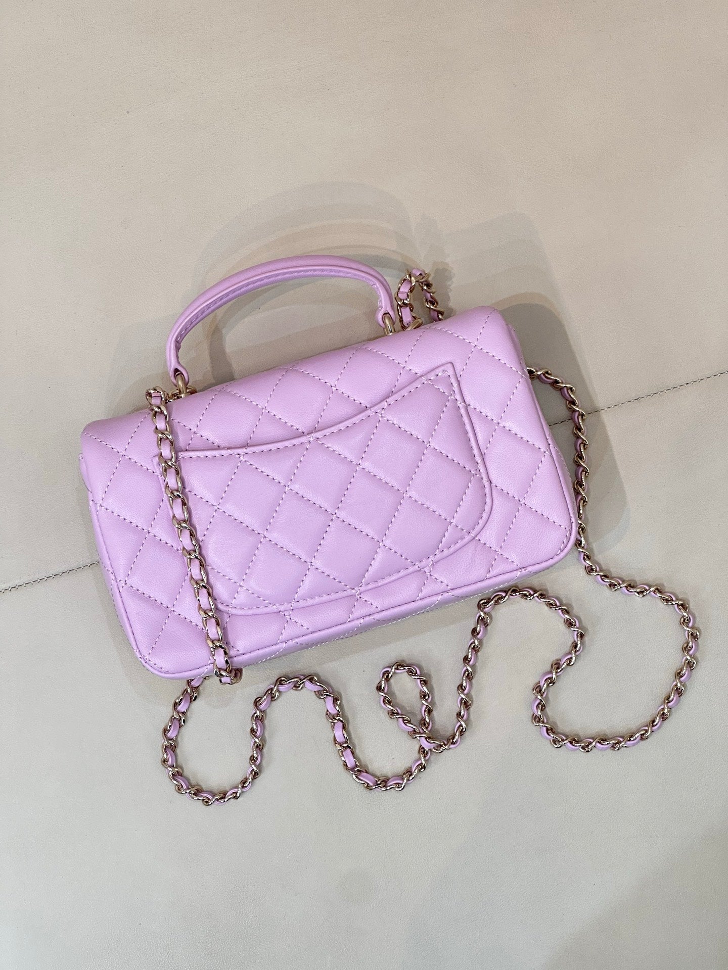 Quilted light purple mini handbag angled view with chain strap and front flap
