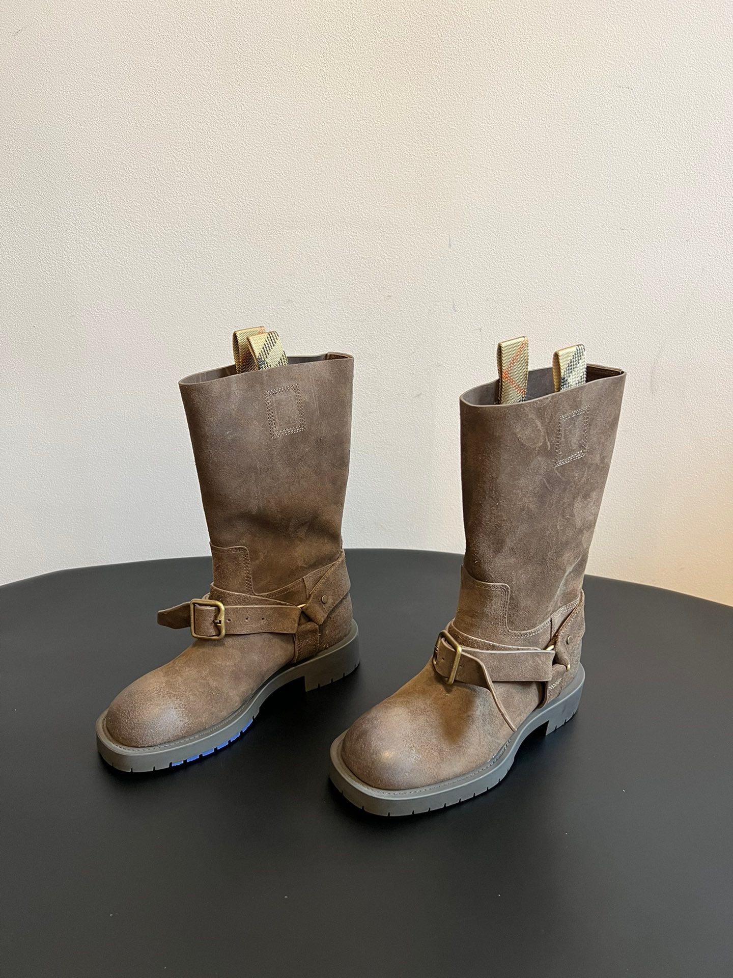 Pair of suede ankle boots with buckled straps and chunky lug rubber soles.