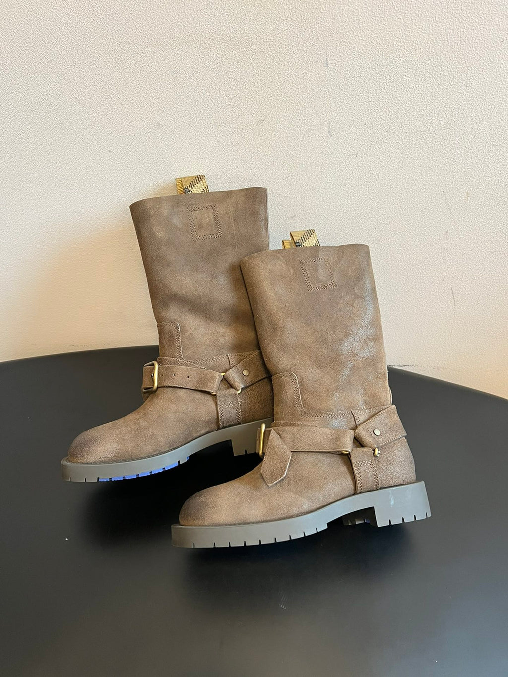 Suede ankle boots with front buckle strap and chunky white lug rubber soles.