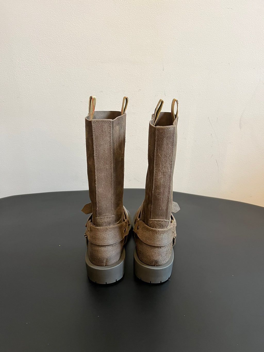 Back view of suede ankle boots with buckled strap accents and lug soles.