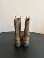 Back view of suede ankle boots with buckled strap accents and lug soles.