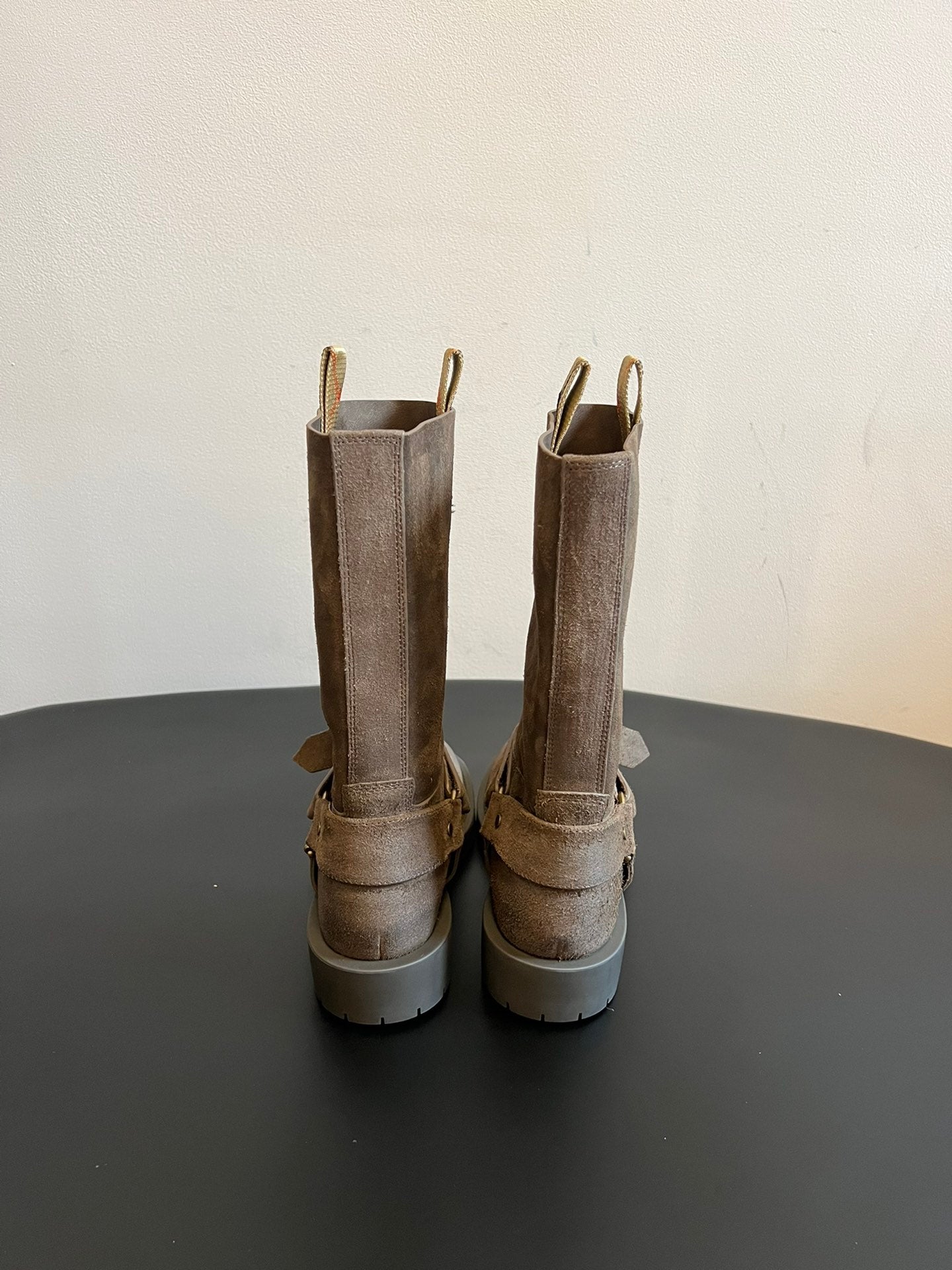 Back view of suede ankle boots with buckled strap accents and lug soles.
