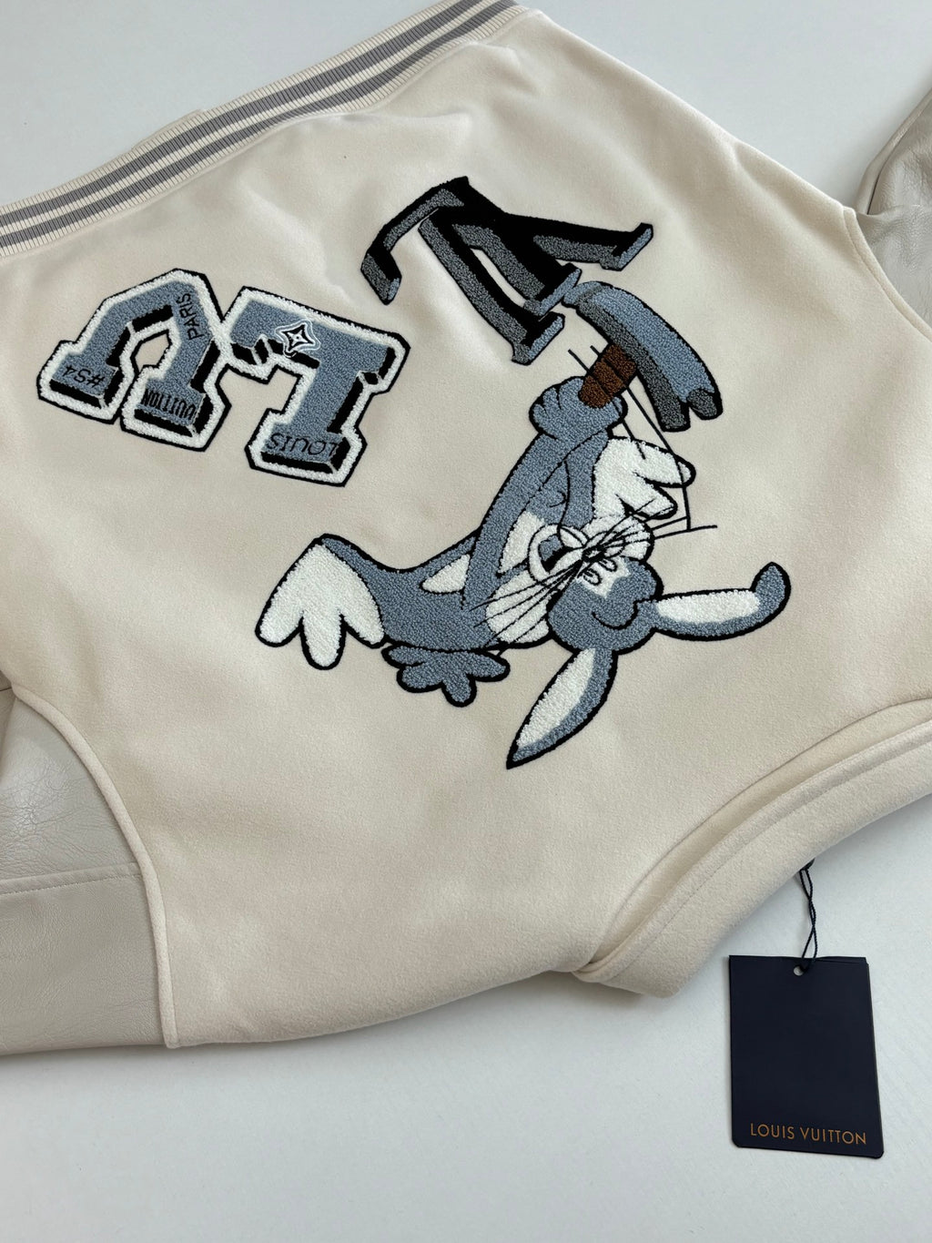Cream long-sleeve jacket with cartoon patch graphics on the front