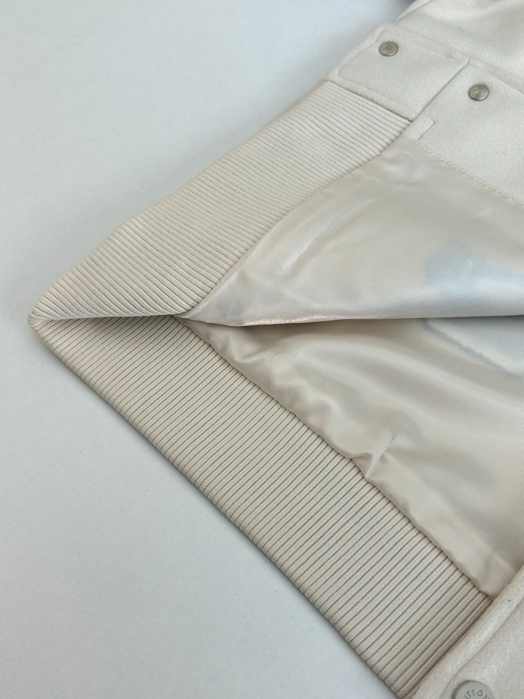 Louis Vuitton cream jacket sleeve with ribbed cuff and snap button placket details