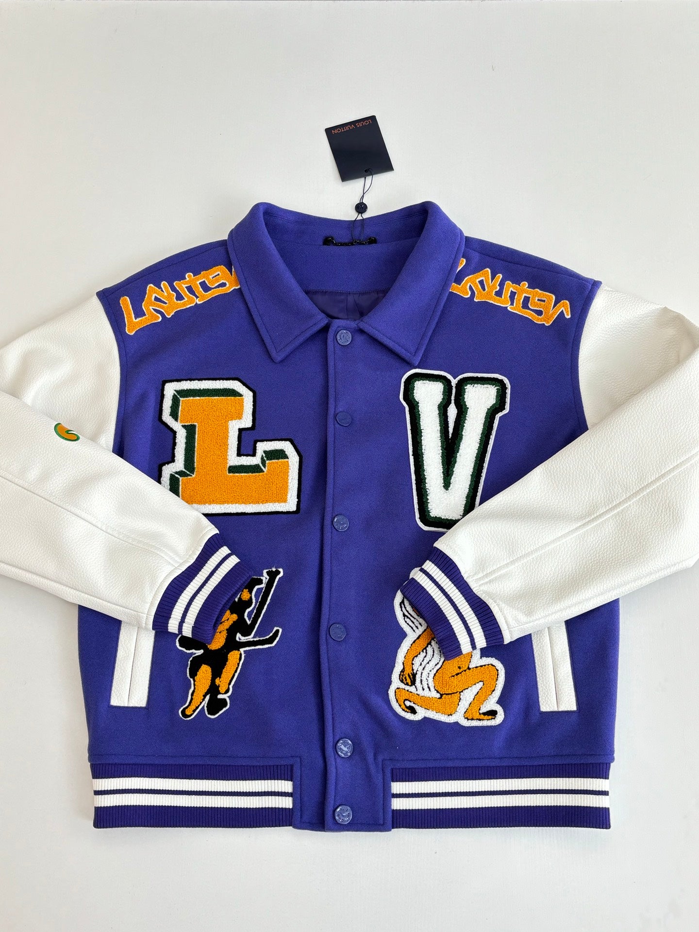 Blue varsity jacket front with button placket, collar, and large L and V appliques