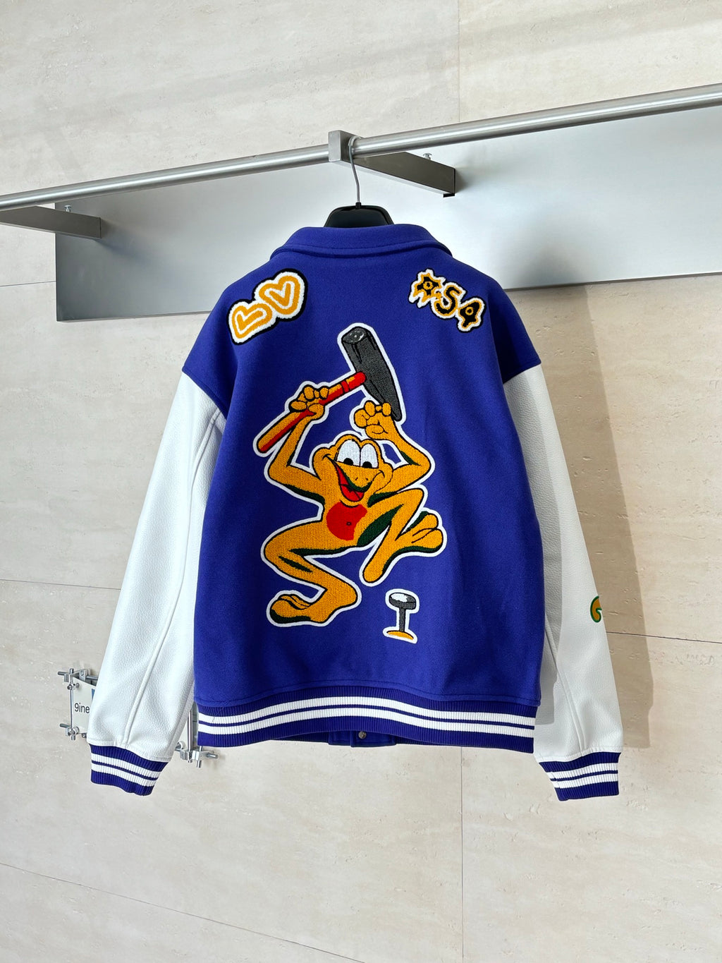 Blue varsity jacket back with cartoon graphic and heart-style patches