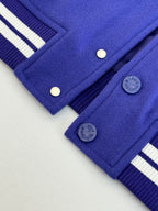 Blue track pants close-up with snap buttons and ribbed cuff detail