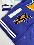 Blue varsity jacket with white stripe bands, ribbed cuffs, and cartoon patch on the sleeve