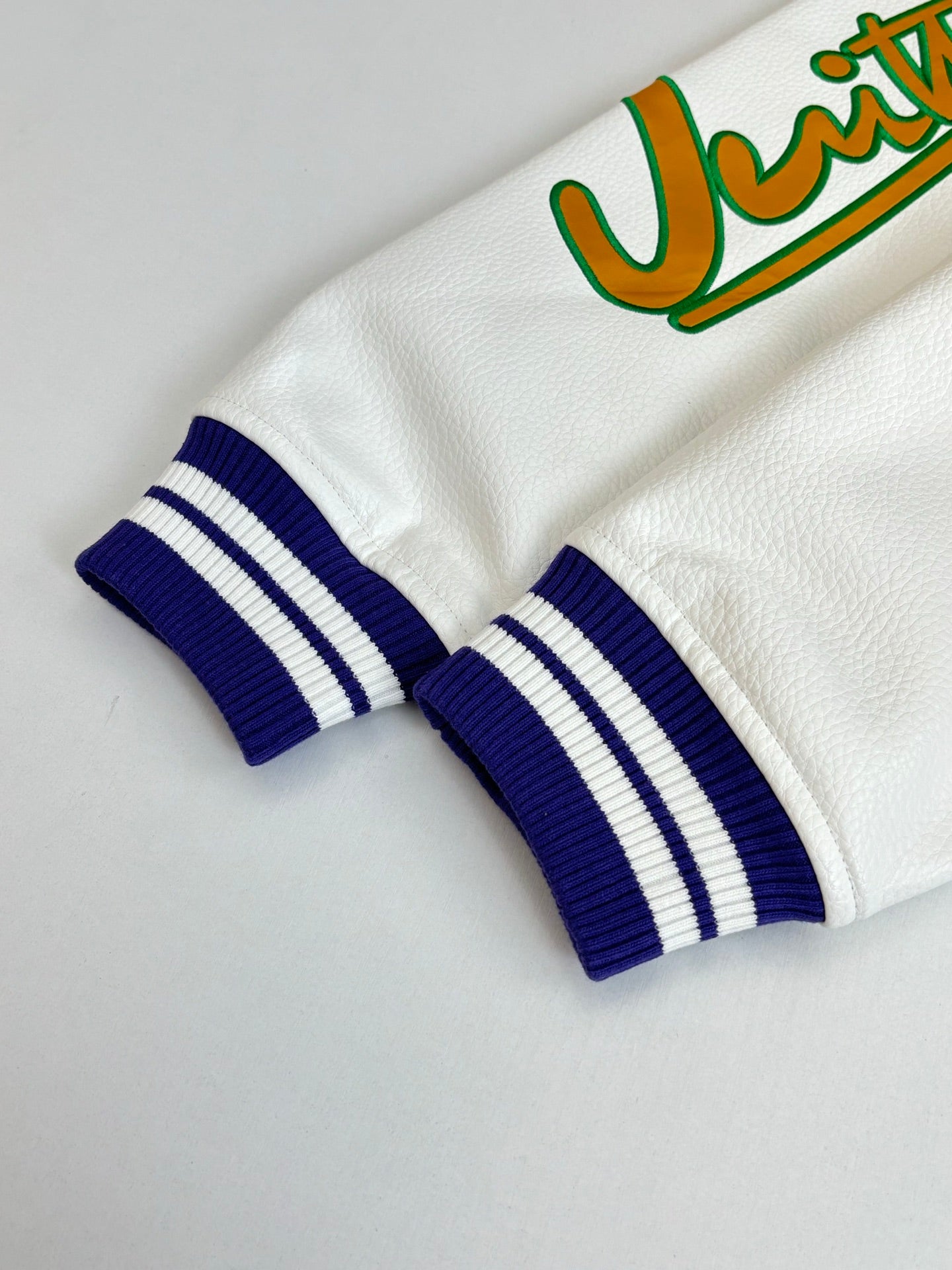 White long-sleeve sweatshirt cuff with blue-and-white striped rib knit