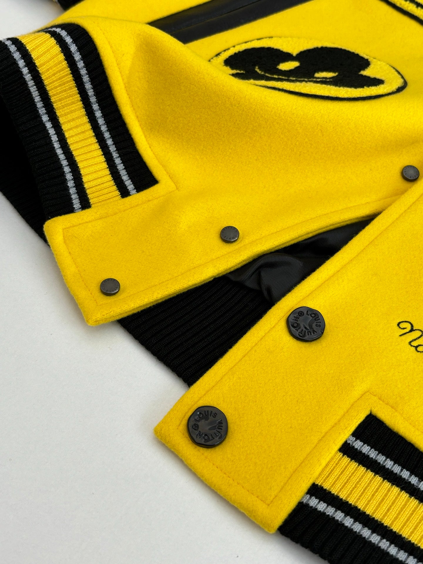 Louis Vuitton yellow and black varsity jacket cuff and hem detail with ribbed stripes and buttons