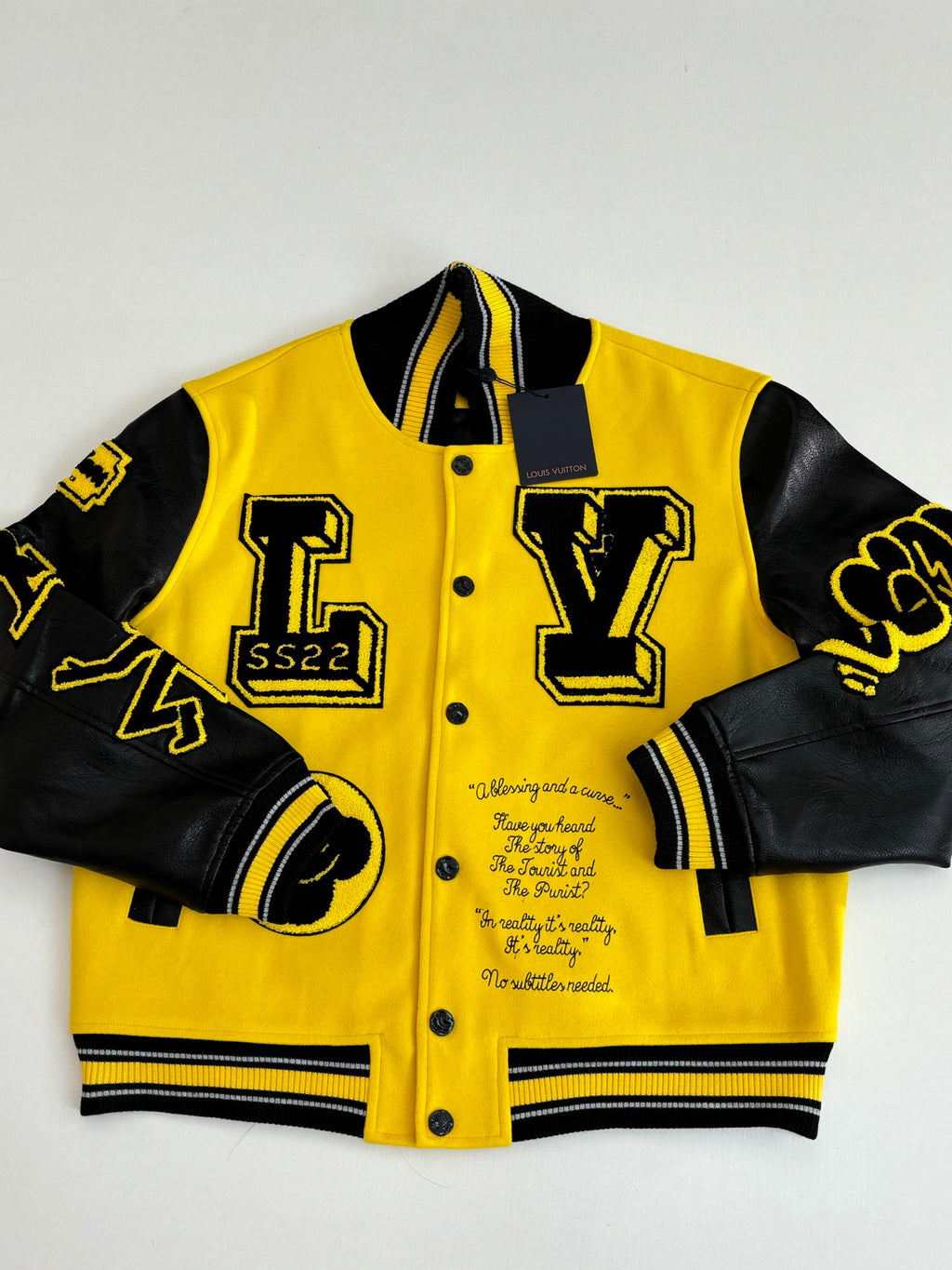 Louis Vuitton yellow and black varsity jacket close-up, front with snap buttons and patches