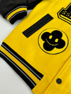 Louis Vuitton yellow and black varsity jacket sleeve detail with Mickey-style patch and rib trim