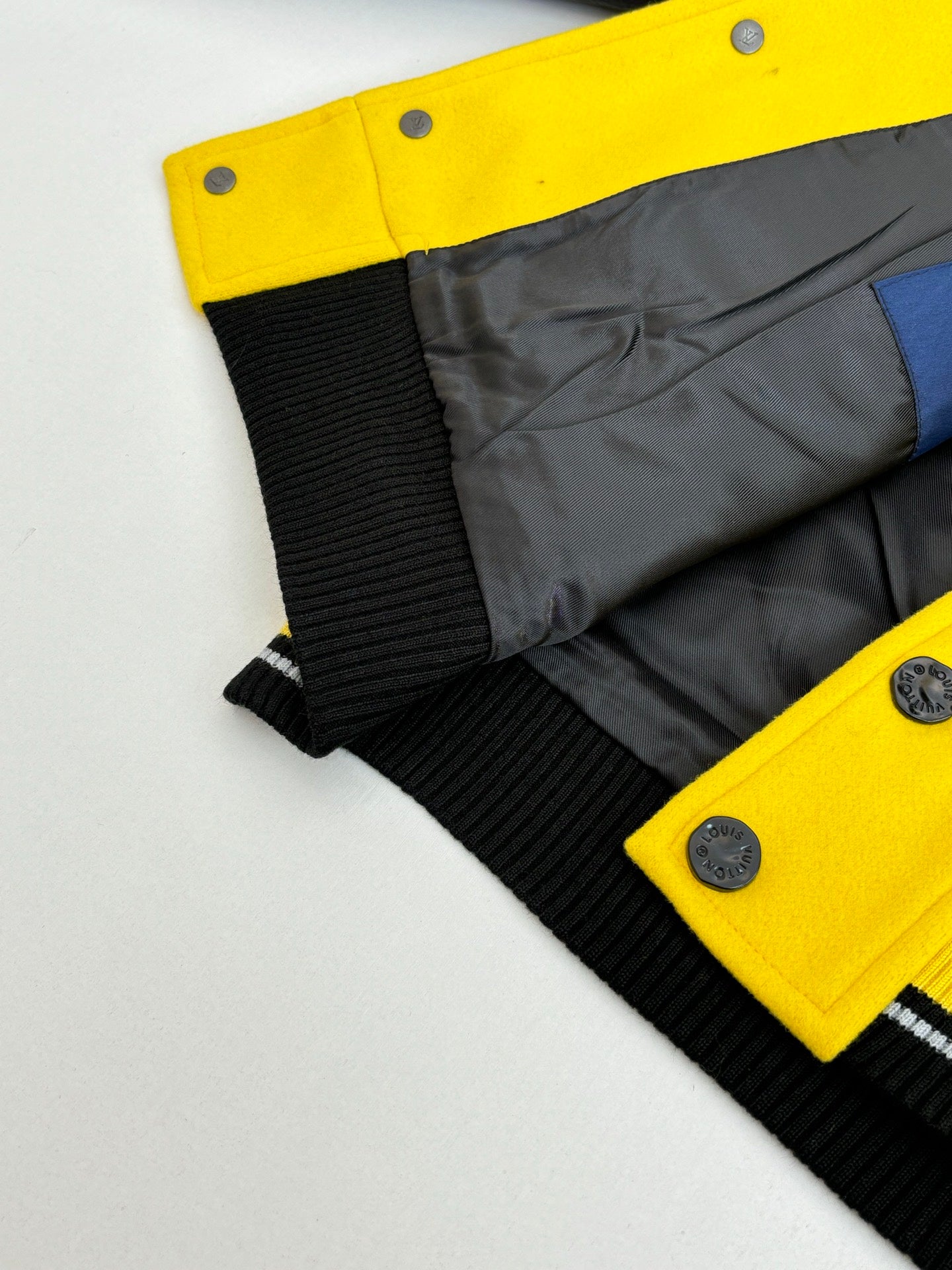 Yellow and dark gray long jacket with black ribbed cuffs and snap buttons