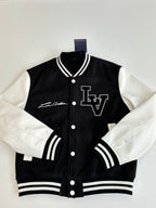 Louis Vuitton varsity jacket front, black with white sleeves, LV logo and snap buttons.