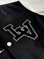 Louis Vuitton varsity jacket detail, black with rhinestone-style arched logo lettering.