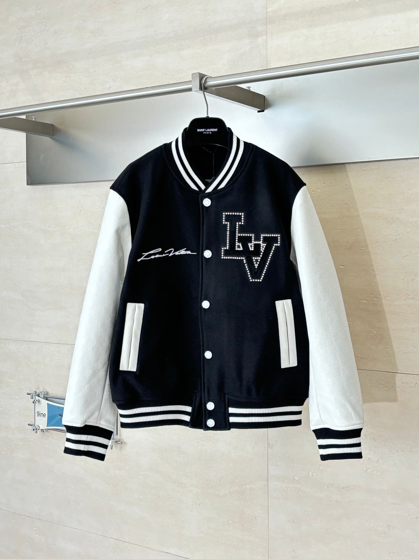 Louis Vuitton varsity jacket, black with white sleeves, button front, striped ribbing.
