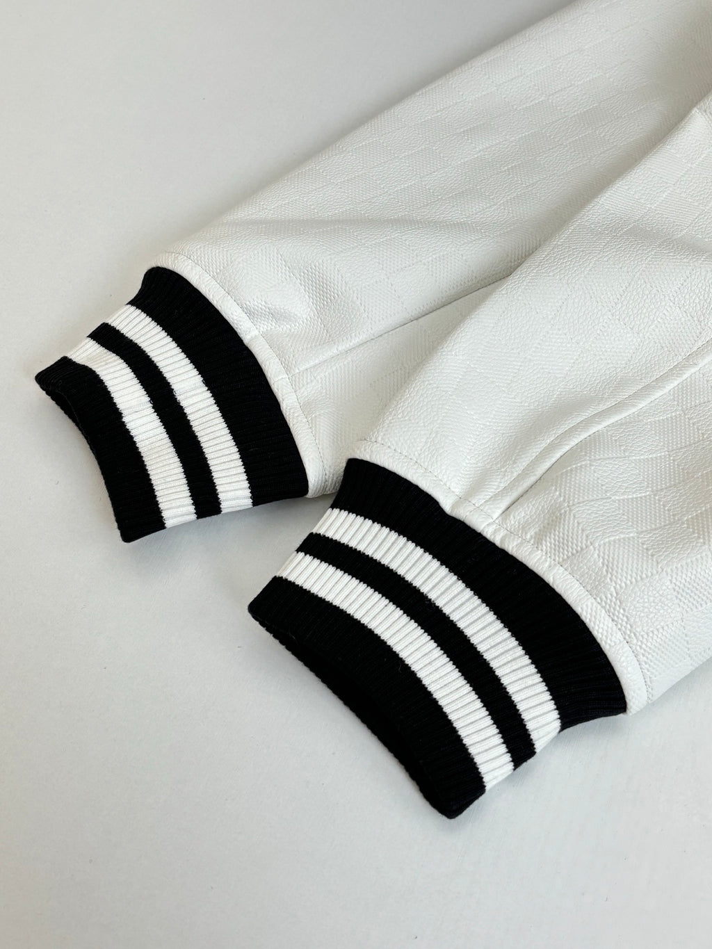 White long pants with black ribbed cuffs and stripe band detail