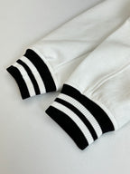 White long pants with black ribbed cuffs and stripe band detail