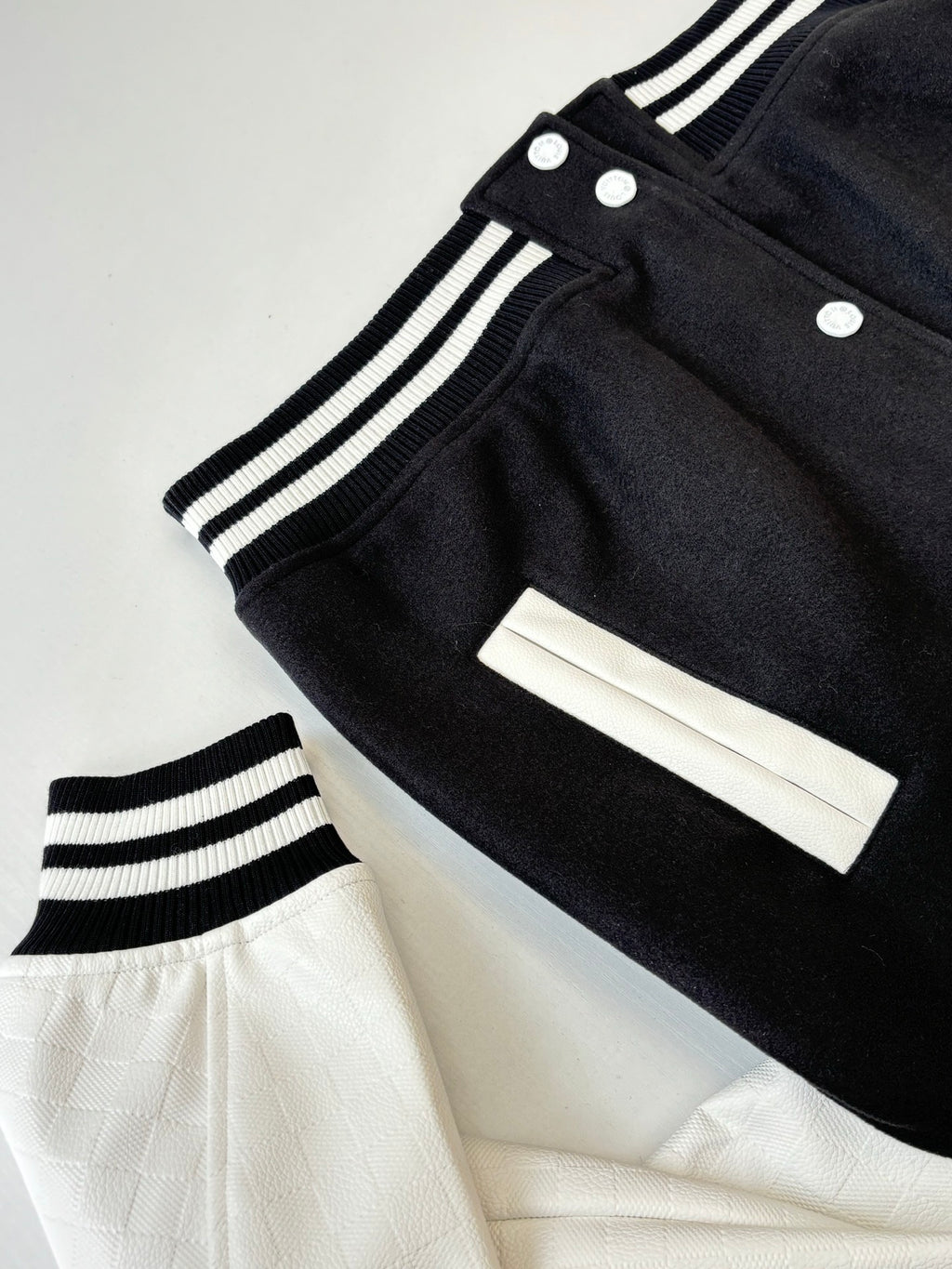 Louis Vuitton varsity jacket cuff detail, ribbed stripes, snap buttons and white panel.