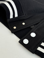 Louis Vuitton varsity jacket sleeve, black ribbed cuff with white stripes and snap placket.