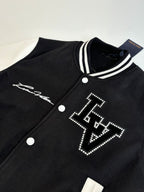 Louis Vuitton varsity jacket close-up, black with white striped collar and studded logo.
