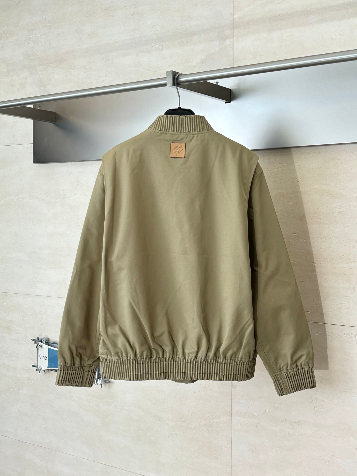Tan bomber jacket back view with ribbed hem and ribbed neck opening