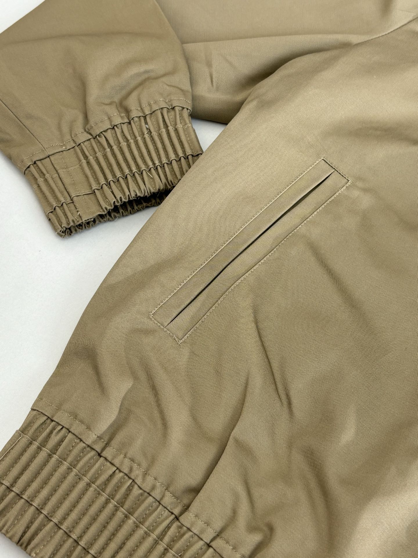 Tan bomber jacket sleeve and hem with ribbed cuffs and stitched side panel