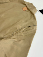 Beige long-sleeve jacket with elastic seam and small leather logo patch